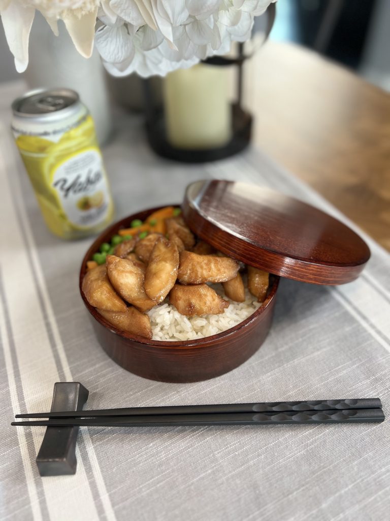 small bowl of rice with sweet miso glazed chicken, peas, and carrots on top; in the background is a can of chu-hai, a Japanese cocktail. 